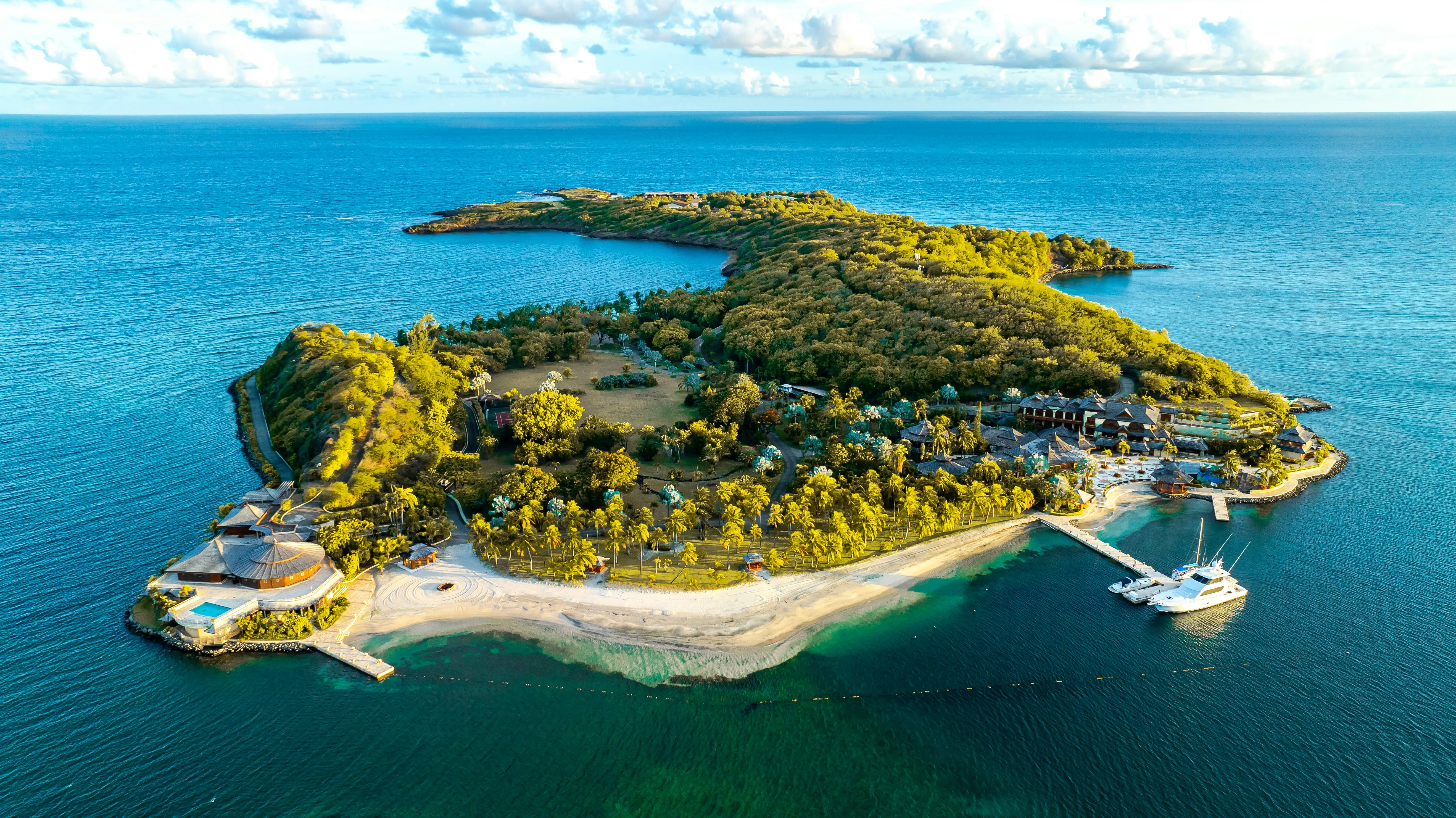 Aerial view of private tropical island resort with secluded beaches and luxury villas