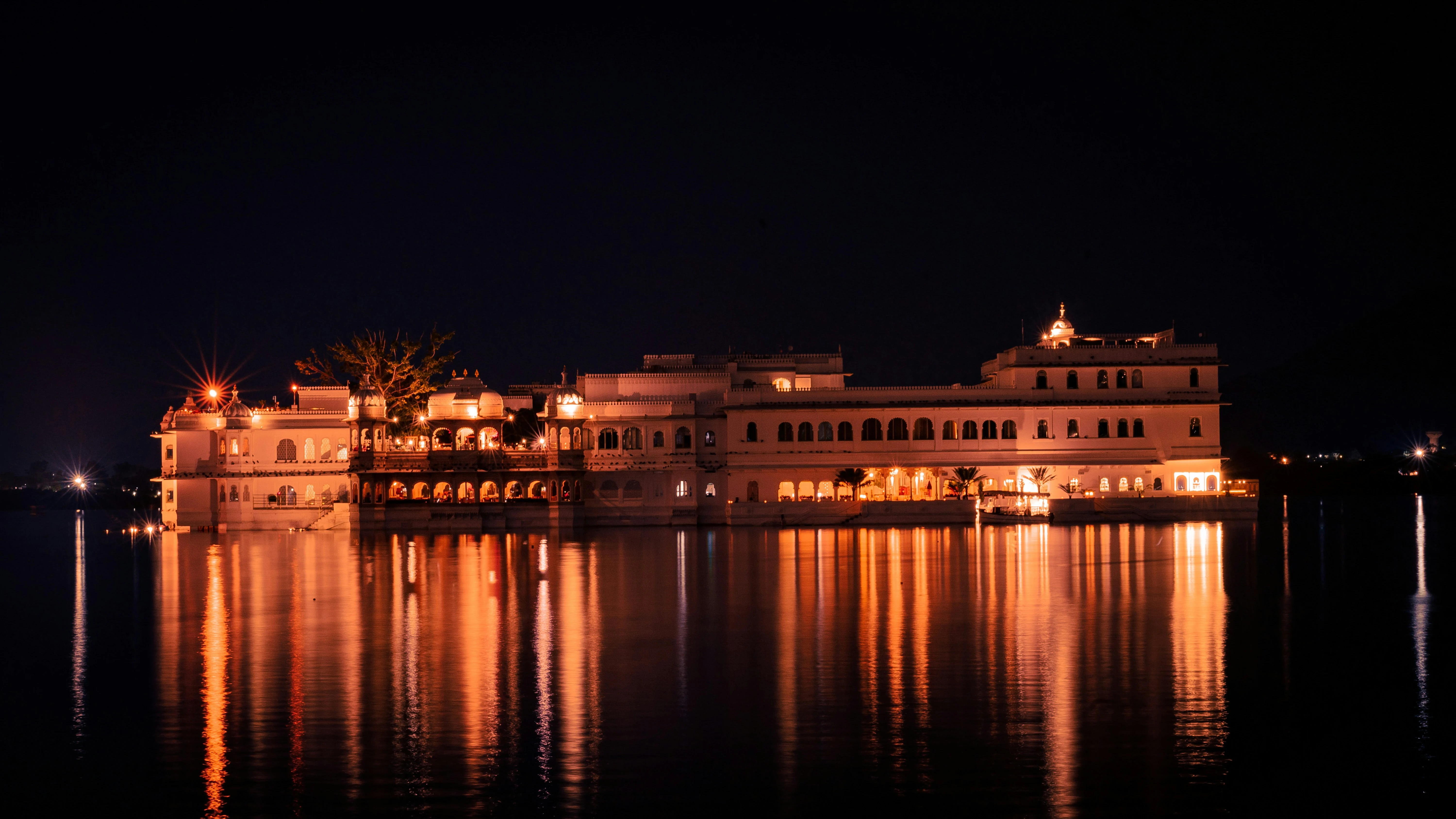 Taj Lake Palace in Udaipur illuminated at night across Lake Pichola